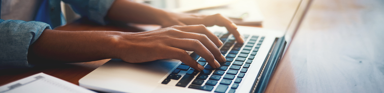 Hands typing on a laptop keyboard
