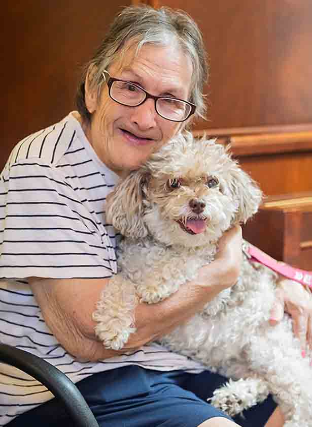 ActivCare has always been a pioneer in residential memory care. Find out why. A happy resident of ActivCare cuddles a dog.