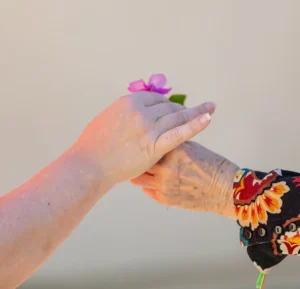 A mother and daughter are holding a flower together at ActivCare